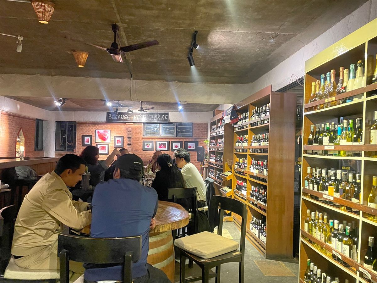 Warm interior of Vino Bistro with wine cellar and barrel tables
