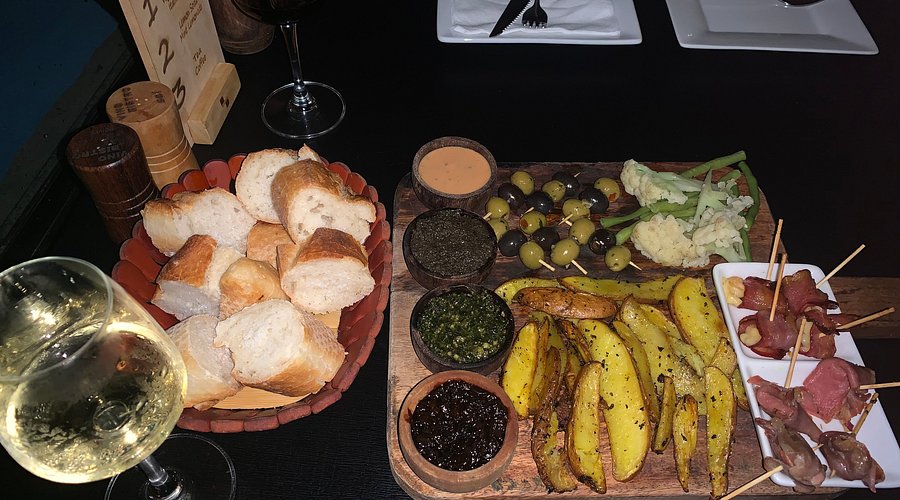Appetizer with bread, olives, skewers and white wine